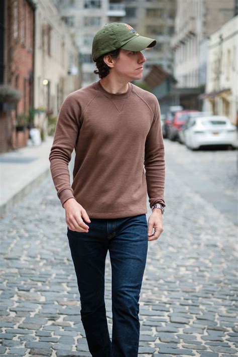 brown sweater with blue pants.